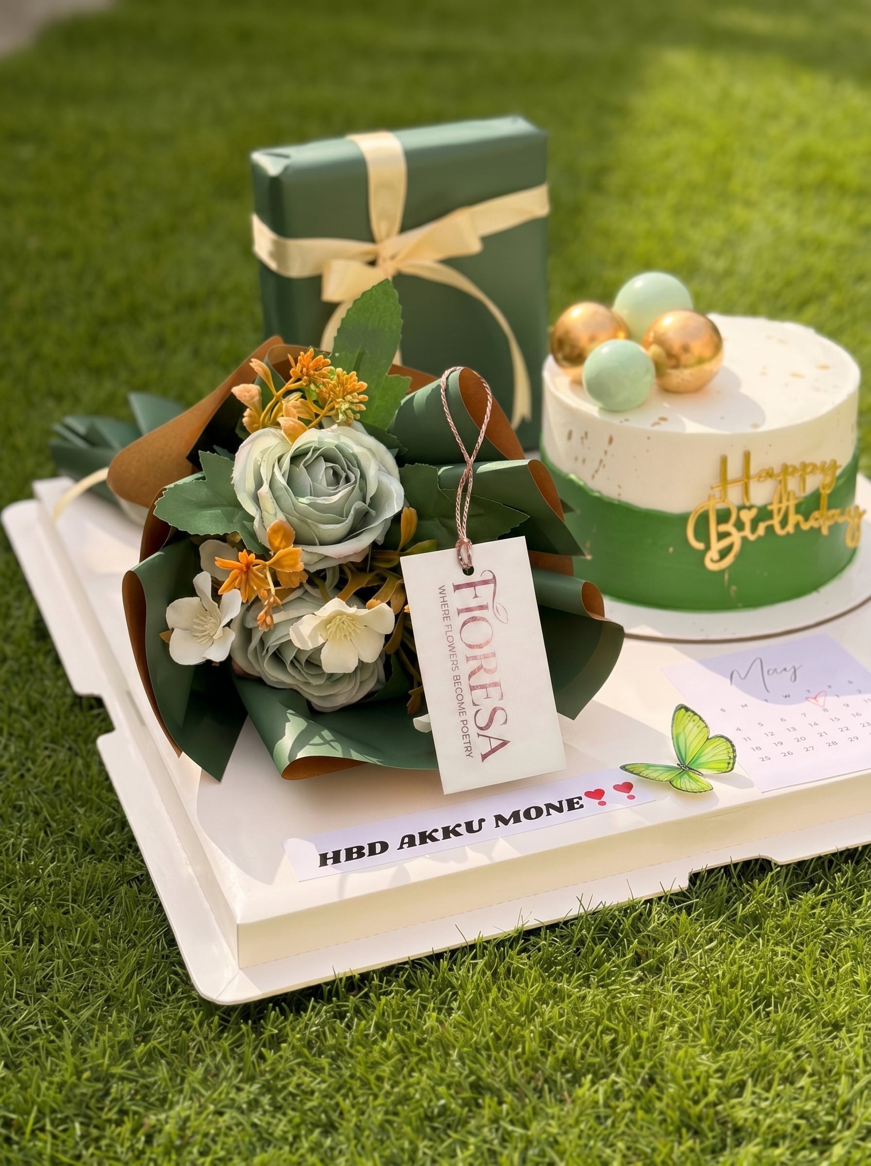 A Fioresa birthday gift combo with a green and white cake, matching bouquet, and wrapped present.