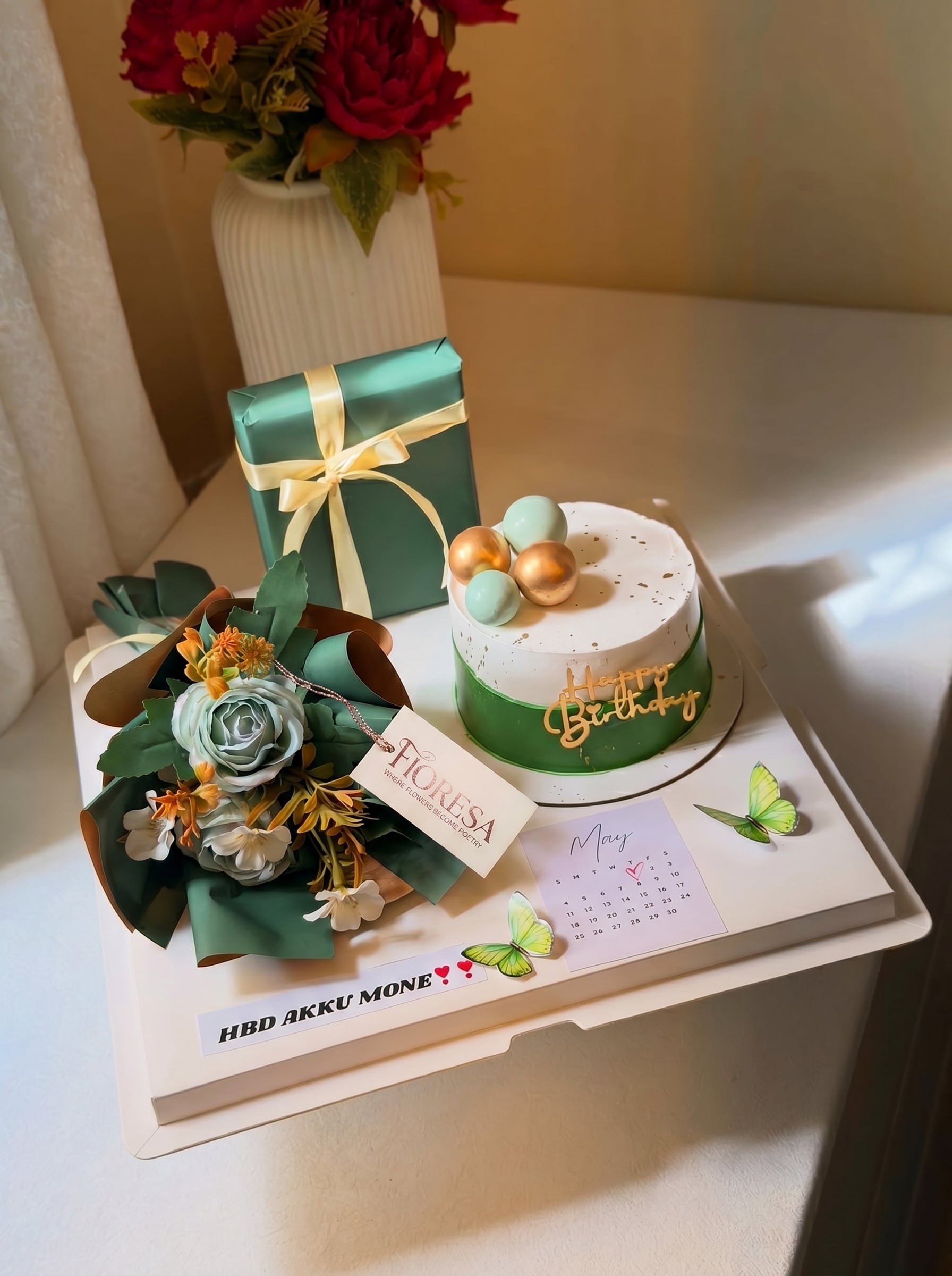 A beautiful Fioresa birthday gift arrangement set featuring a green-themed cake, bouquet, and gift box.